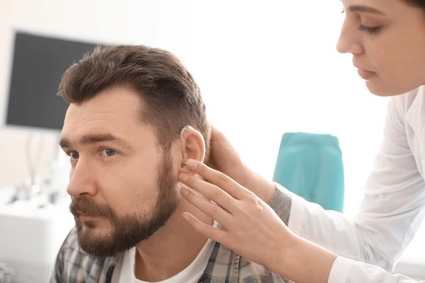 Audioprothésiste mettre prothèse auditive dans l'oreille de l'homme